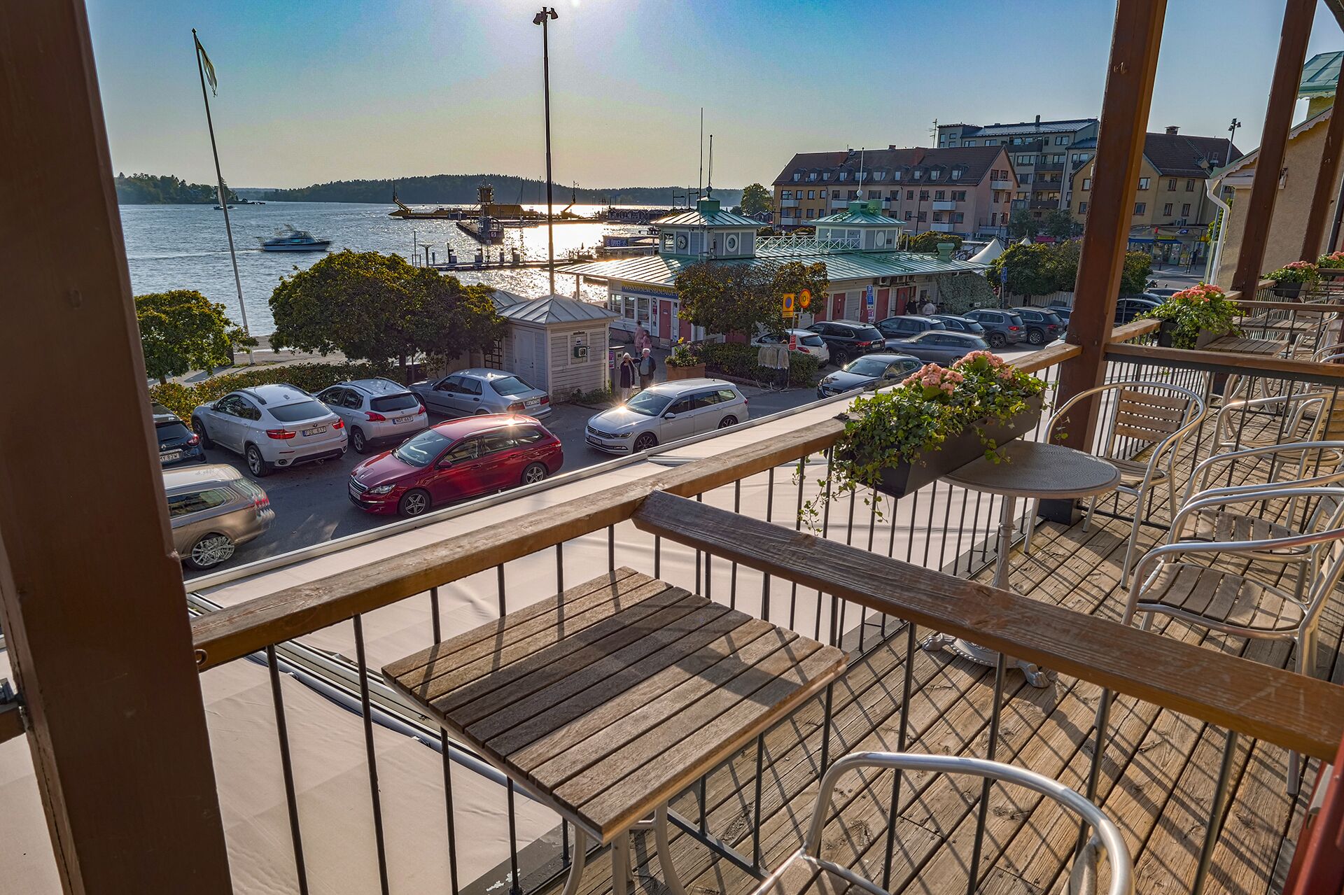 A balcony with a view of a marina and parked cars.