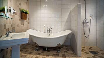 A bathroom with a freestanding bathtub, a sink, and a shower.