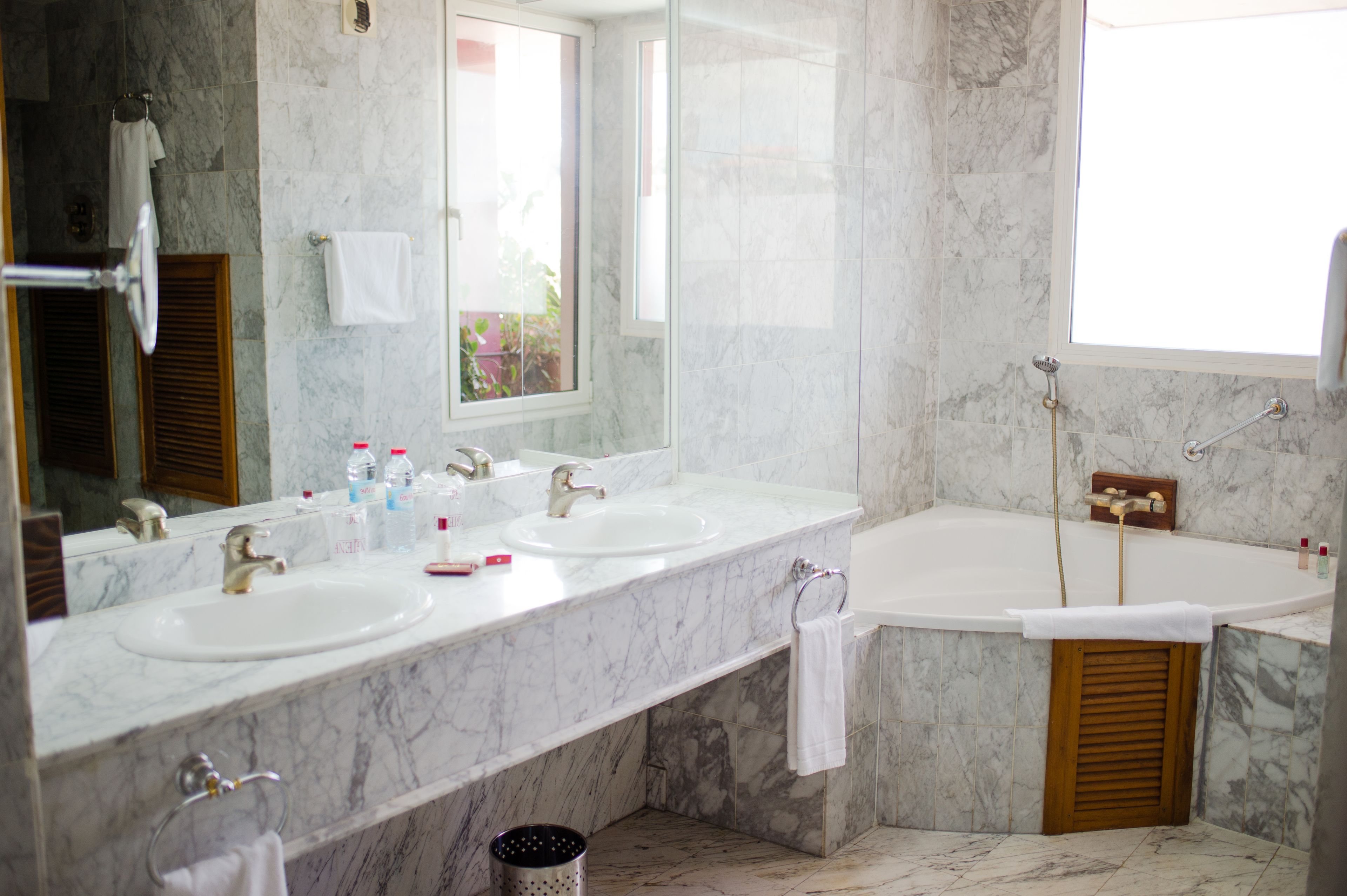 A bathroom with two sinks, a large mirror, and a bathtub.