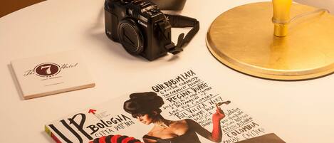 A camera, a magazine, and a lamp on a round table.