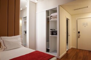A bedroom with a bed, a wardrobe, and a door.