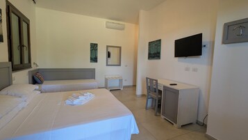 Habitación de hotel con dos camas, un escritorio, una silla, un televisor y un espejo.