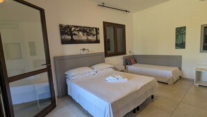 A bedroom with two beds, a nightstand, a mirror, and artwork on the walls. - Agrialbergo Capalbio La Sugherella (Capalbio)
