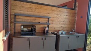 A compact kitchenette with a built-in microwave, coffee maker, and a small countertop with cups and a tray. - Agrialbergo Capalbio La Sugherella (Capalbio)