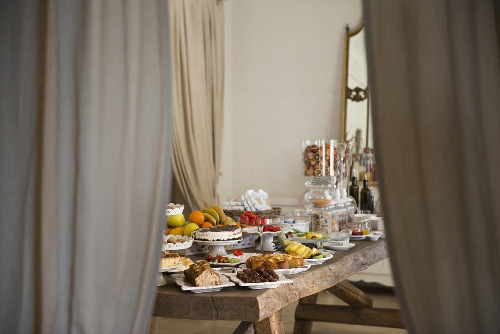 A buffet table with various food items and a decorative centerpiece.
