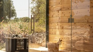 A modern room with a glass wall, wooden ceiling, and a view of the outdoors. - Masseria San Francesco (Fasano)