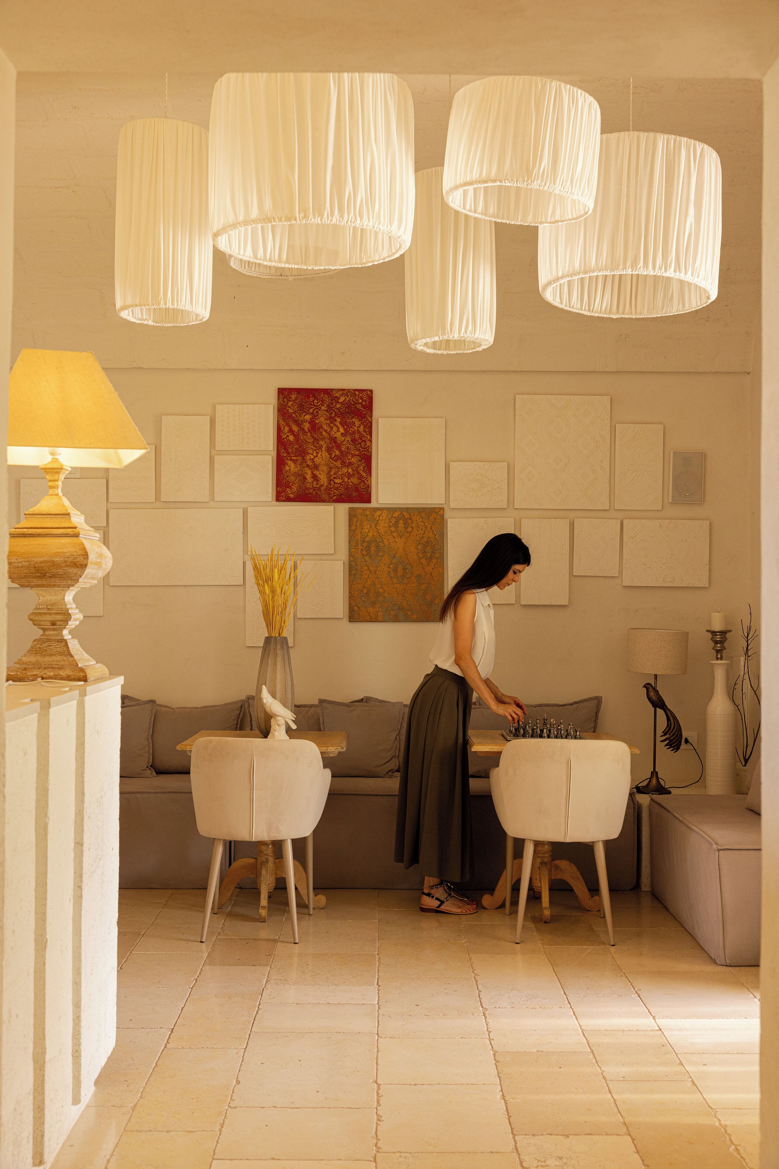 Ein modernes Wohnzimmer mit einer Couch, zwei Sesseln, einer Lampe und Wanddekoration.