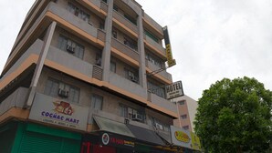 A multi-story building with a sign for Mango Inn hotel, a liquor store, and a Korean food restaurant. - OYO 790 Mango Inn (Manila)