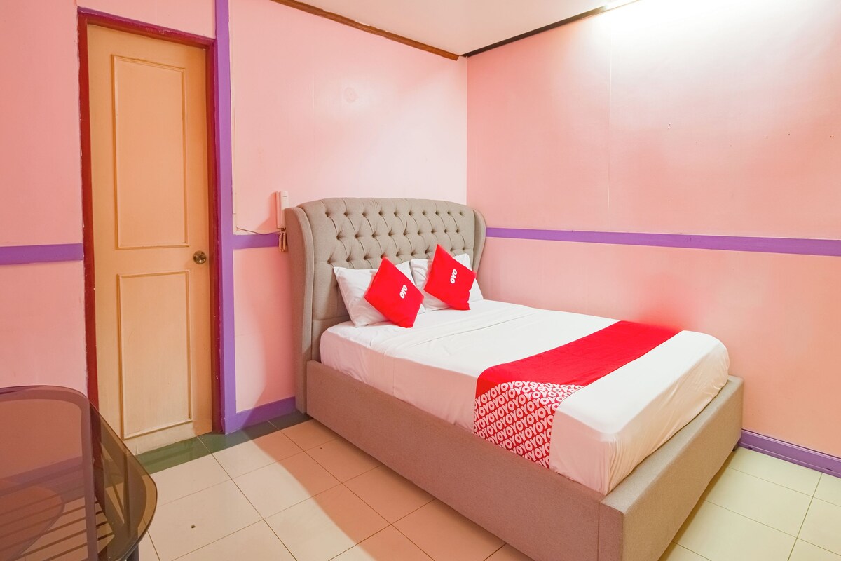 A bedroom with a bed, a door, and a chair.