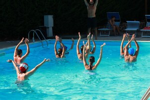 Una piscina al aire libre de temporada, sombrillas