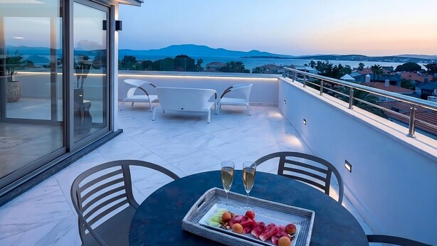 A rooftop terrace with a table set for two, a tray of a - Kalyon Çeşme (Cesme)