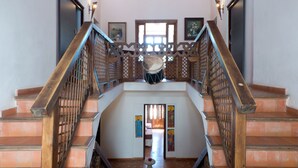 A staircase with wooden railings and a tiled floor. - Casa Bombo (Granada)