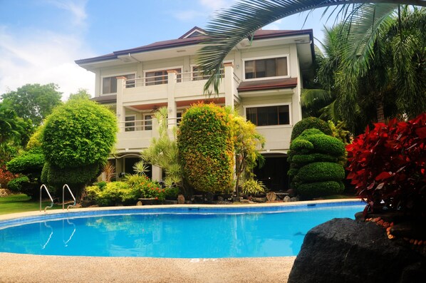 A two-story building with a swimming pool in front. - Golden Palm Resort (Panglao)