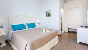 A neatly arranged bedroom with a bed, bedside tables, a wardrobe, and a small artwork on the wall. - Aqua Marina (Rethymno)