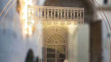 Una ventana de vidrio con un dibujo arquitectónico decorativo de un edificio y el texto