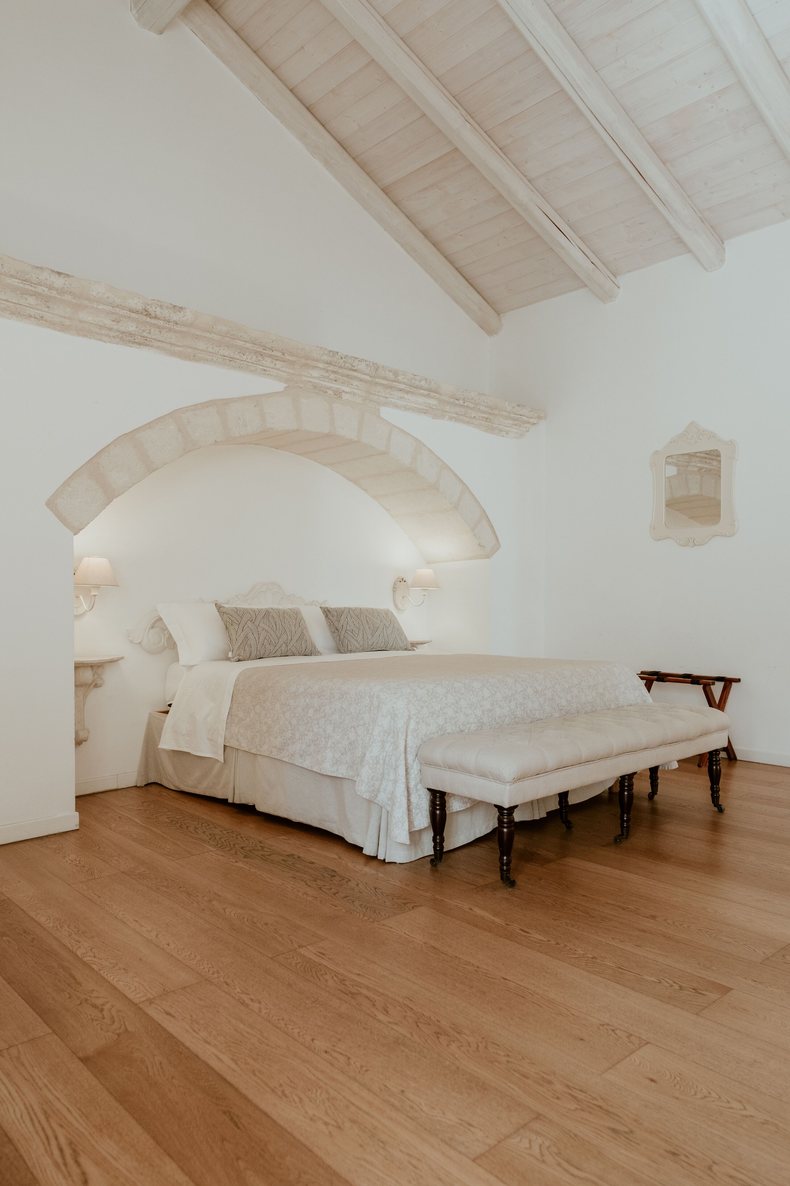 Una camera da letto con un letto, una panca e un tavolino.