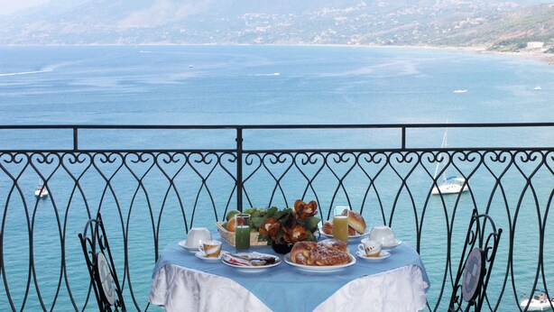 A table set with breakfast items overlooking a coastal view. - Hotel Palinuro (Centola)