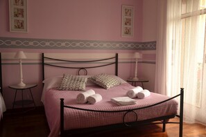 A bedroom with a bed, two bedside tables, a lamp, and a window with curtains. - B&B Tosca (Verona)