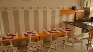 A dining area with striped wallpaper, a kitchen counter, and a stove. - B&B Tosca (Verona)