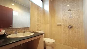 A bathroom with a sink, toilet, and a mirror.