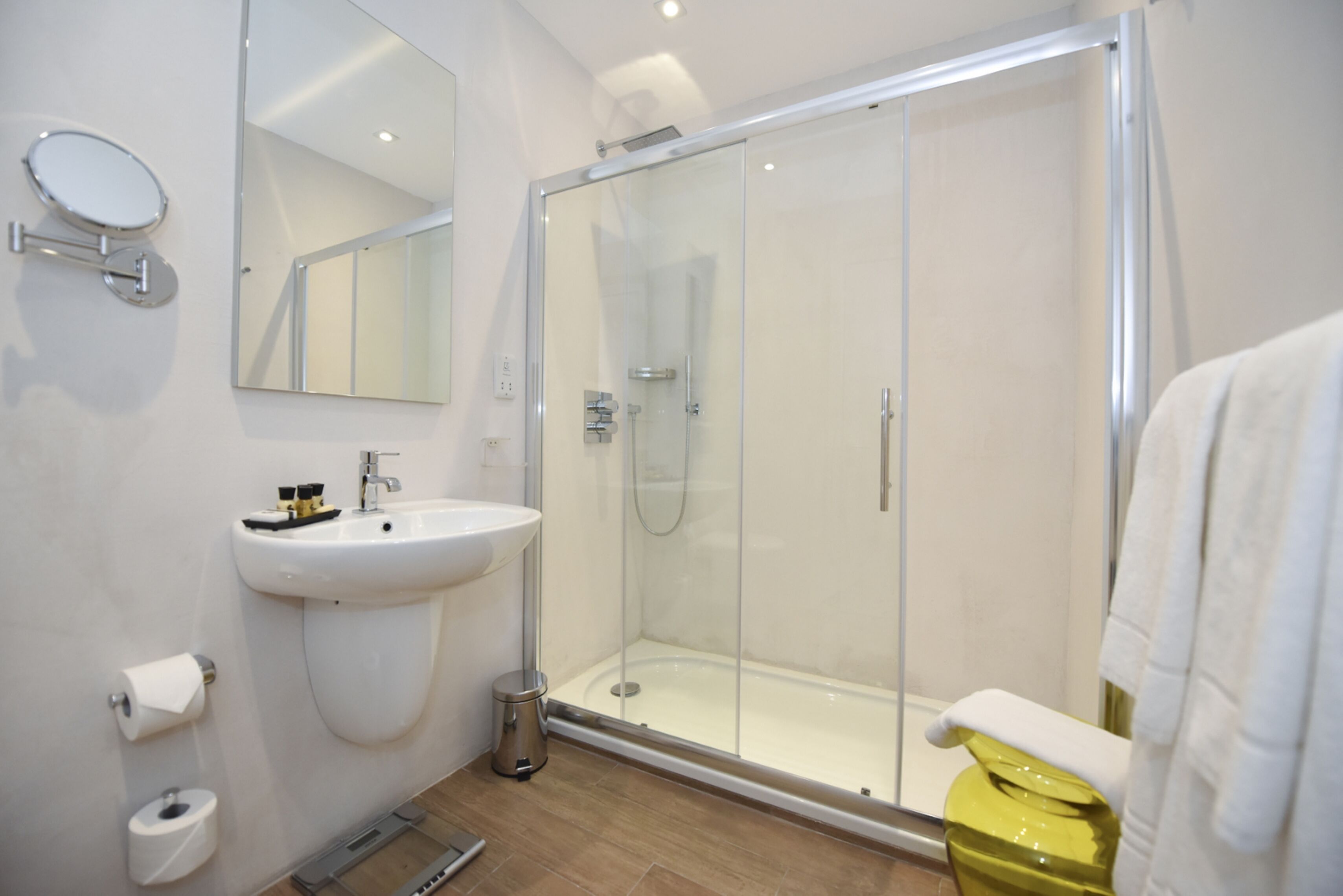 Une salle de bain moderne avec une douche à parois de verre, un lavabo avec un miroir et des toilettes.