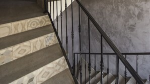 Una escalera con peldaños estampados y barandilla de metal.