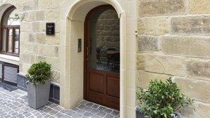 Un edificio de piedra con una puerta de madera y dos macetas.