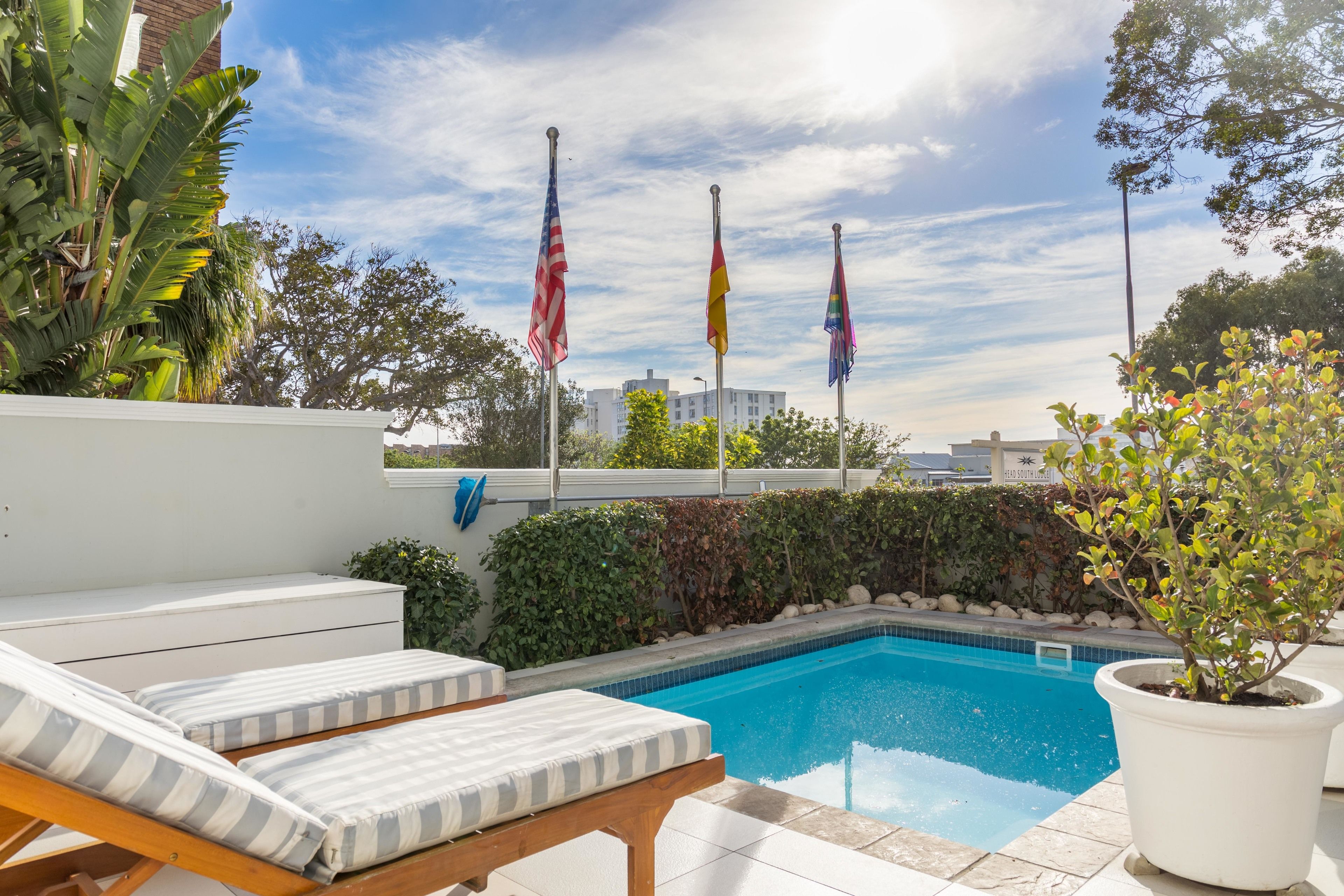 Una piscina al aire libre, sillones reclinables de piscina