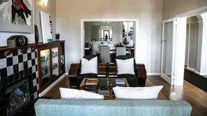 Un salon spacieux avec une cheminée, un ensemble de canapés et une table basse.