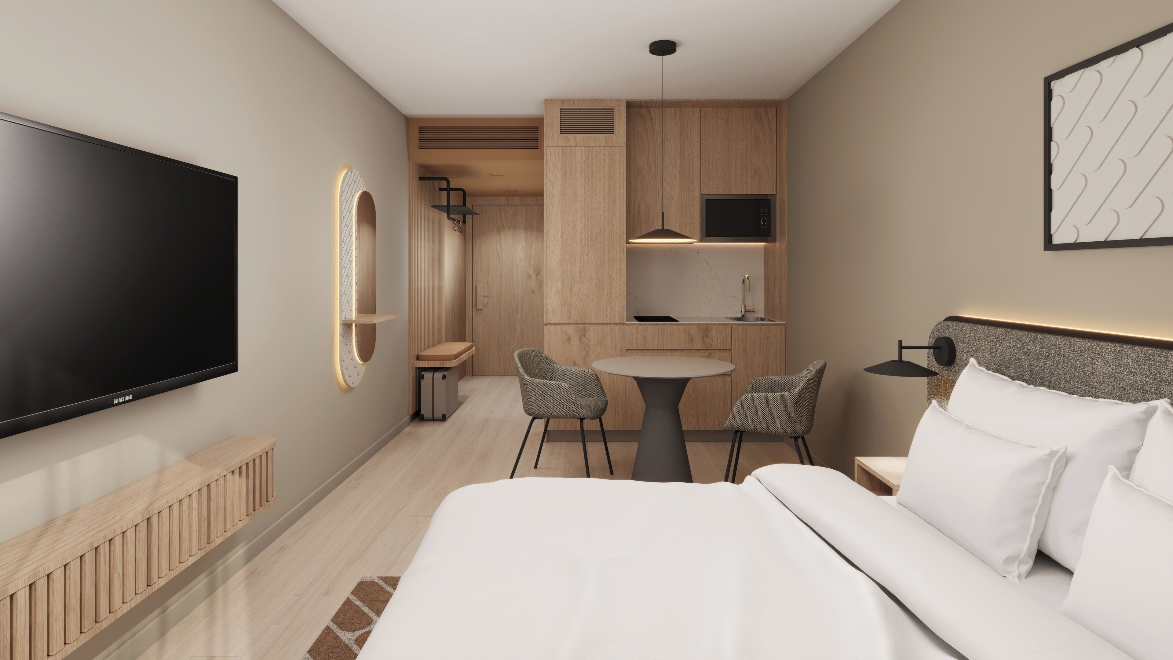 A hotel room with a bed, a TV, a desk with chairs, a kitchen area, and a bathroom.