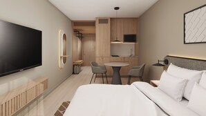 A hotel room with a bed, a TV, a desk with chairs, a kitchen area, and a bathroom.