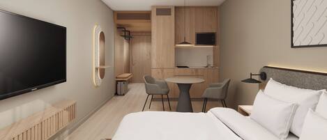 A hotel room with a bed, a TV, a desk with chairs, a kitchen area, and a bathroom.