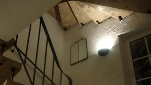 A staircase with wooden steps and black metal railings, leading to an upper level with a sloped ceiling and a window. - Hotel Bürgerbräu (Osnabrueck)