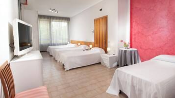 Ein Hotelzimmer mit zwei Betten, einem Fernseher, einem Schreibtisch und einem Stuhl.