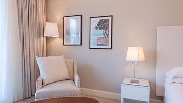 Suite junior, vista al lago | Edredón, minibar, caja de seguridad en la habitación y escritorio