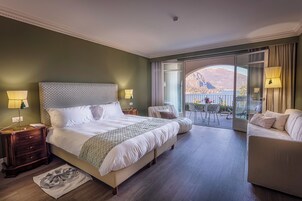 Junior suite, uitzicht op meer | Donzen dekbedden, een minibar, een kluis op de kamer, een bureau