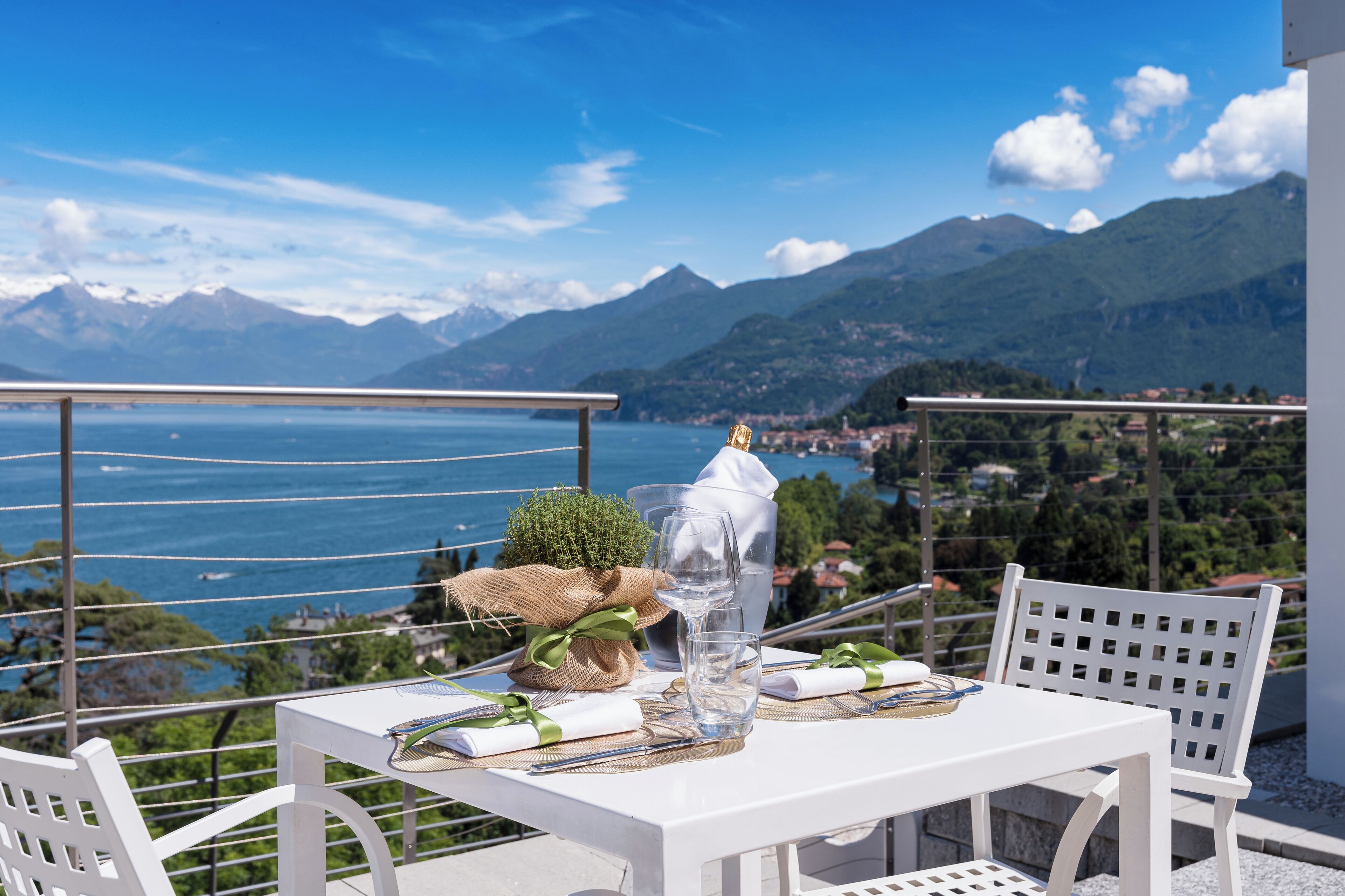 A table set for two with a clear view of the sea and mountains in the background.