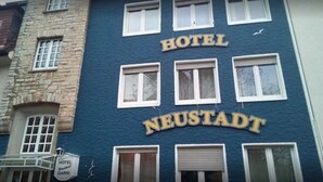 Ein Hotelgebäude, auf dem der Name "HOTEL NEUSTADT" deutlich sichtbar ist.