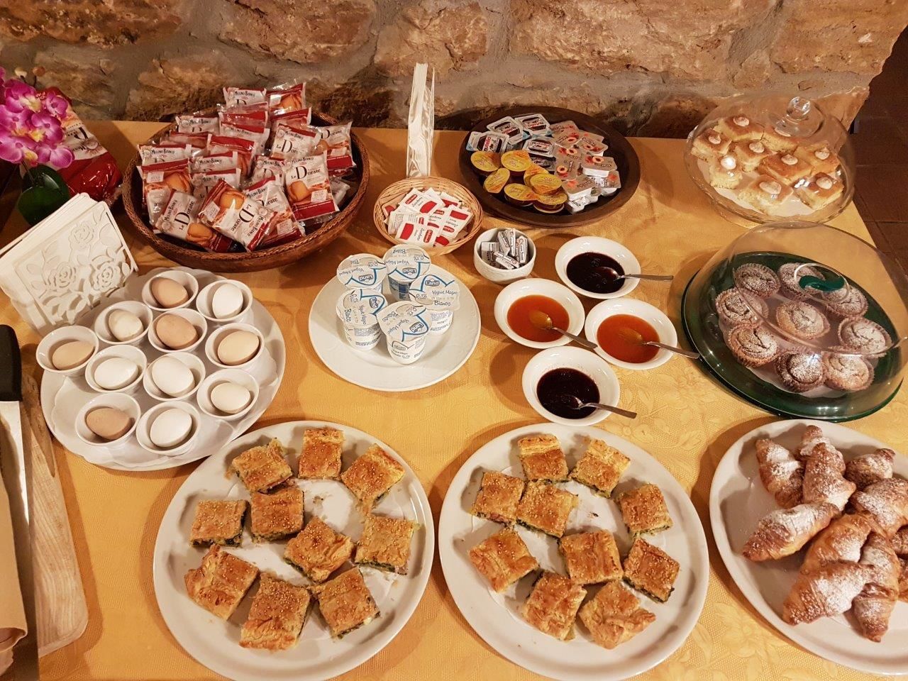 A table with various food items including pastries, cookies, and dips.