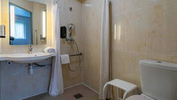 A bathroom with a sink, mirror, shower, and toilet.