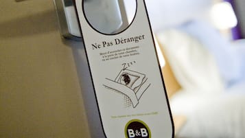 Een hotelkamerdeur met een kaartlezer en een toegangskaart met een Franse boodschap.