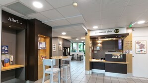 A modern interior with a reception desk, seating area, and a sign reading "Bienvenue chez B&B." - B&B HOTEL Toulouse Basso Cambo (Toulouse)