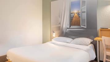 Un dormitorio con cama, mesita de noche, silla y lámpara de pared.
