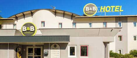 A B&B hotel with a signboard, entrance, and a visible reception area.