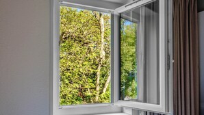 Una ventana con vistas a una zona arbolada.