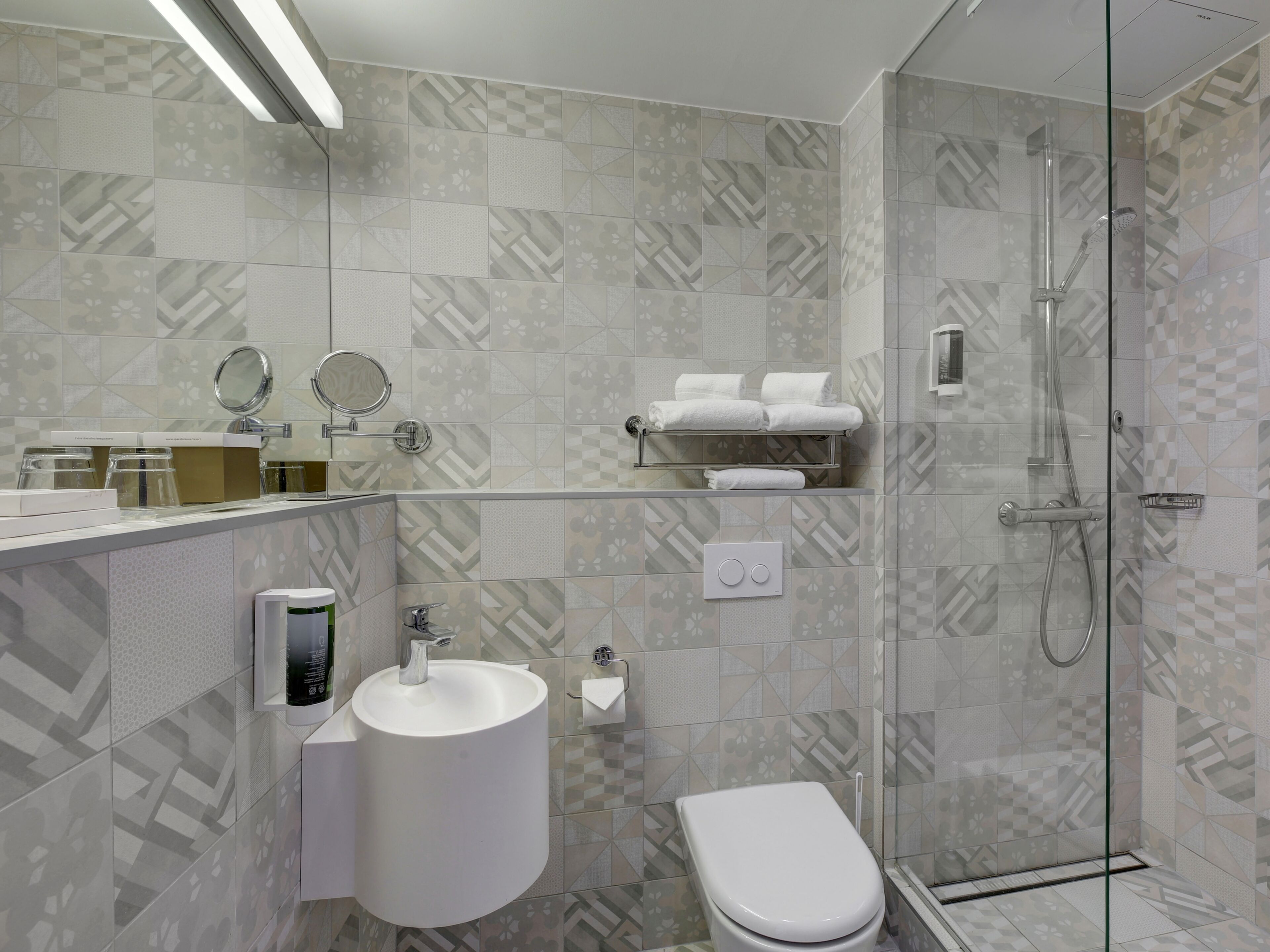 A modern bathroom with a toilet, sink, and glass-enclosed shower.