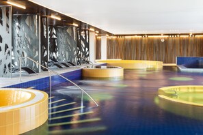 A modern indoor pool area with multiple hot tubs and a central water feature. - Estonia Resort Hotel & Spa (Parnu)