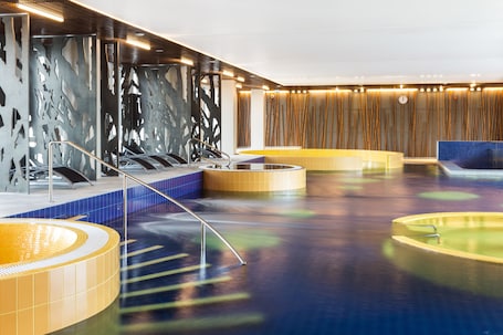 Una piscina techada, sillones reclinables de piscina