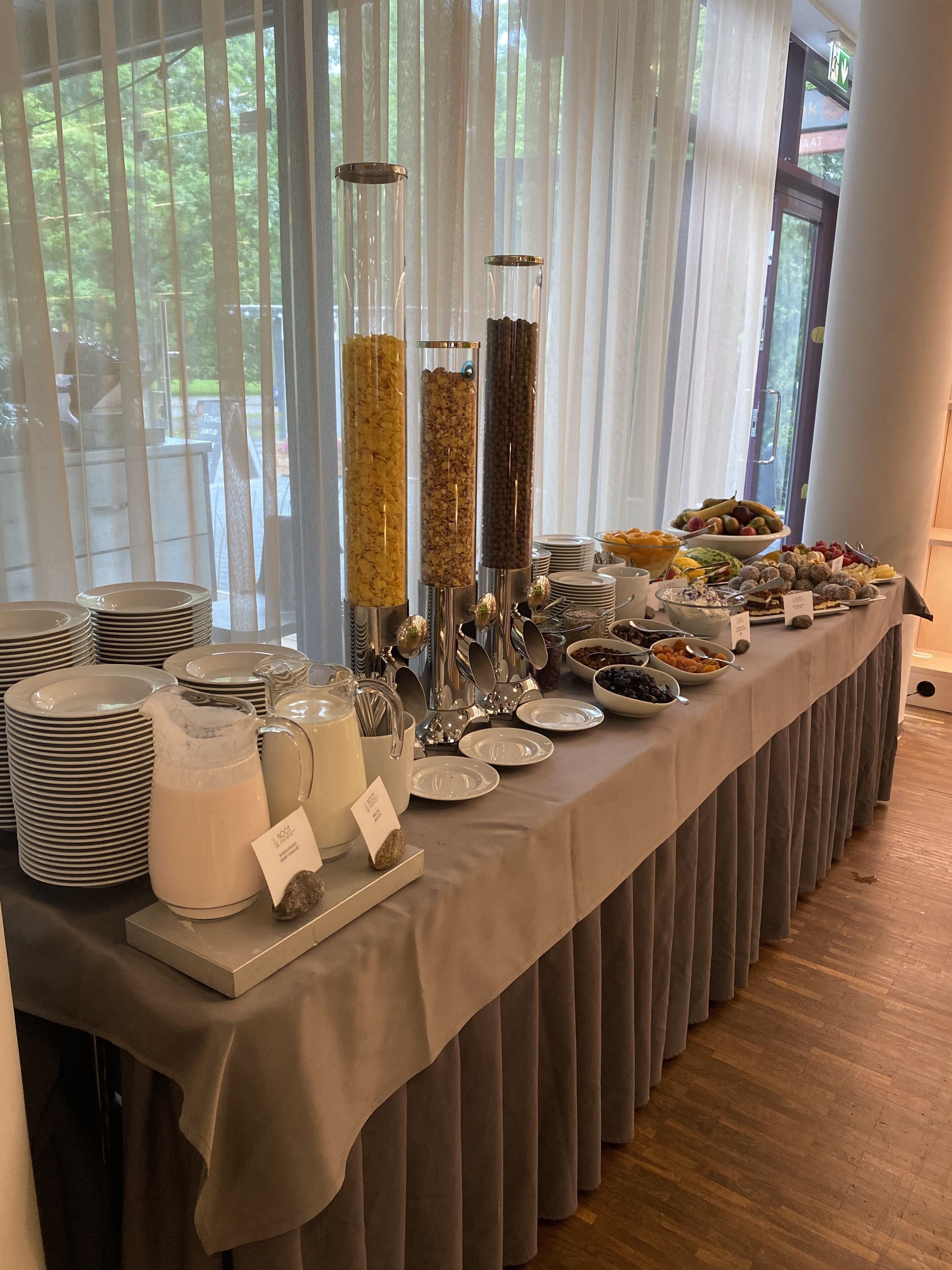 A buffet setup with various food items and serving utensils.