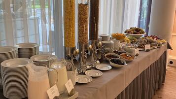 A buffet setup with various food items and serving utensils.
